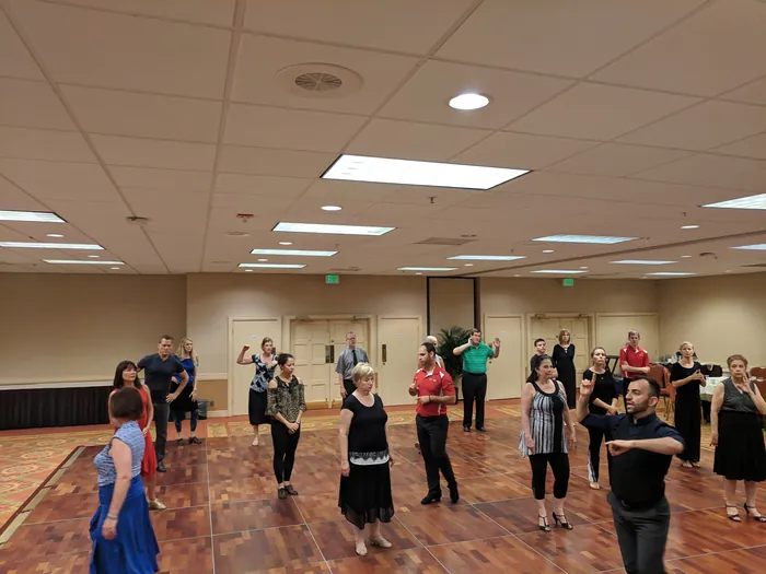 Students standing in loose rows mid-class, watching the front of the room