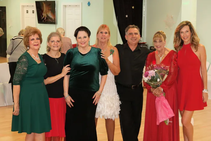 The Dance Passion Divas posed together, several holding bouquets