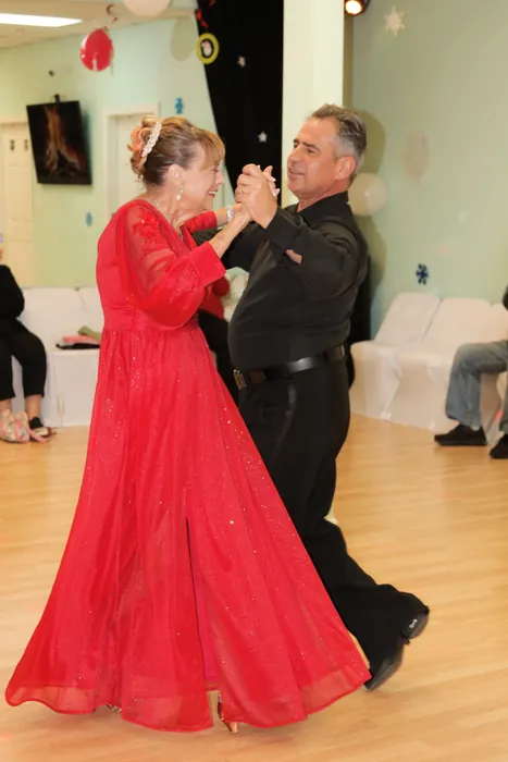 Eleanor in a full-length red ballgown turning with Ivan