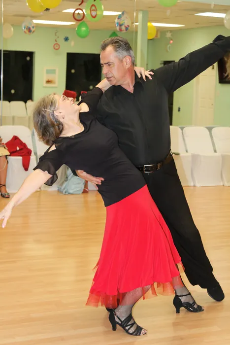 Lourdes bending back over Ivan's arm in a dramatic line