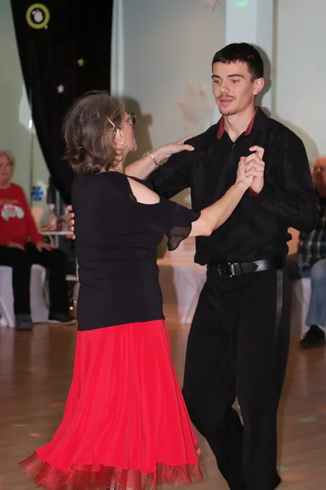 Lourdes in a red tulle skirt dancing hand in hand with Victor