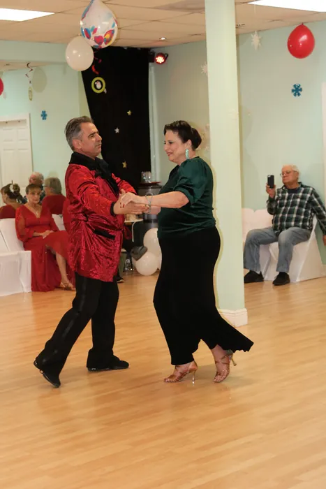 Sharon and Ivan dancing at arm's length as seated guests look on