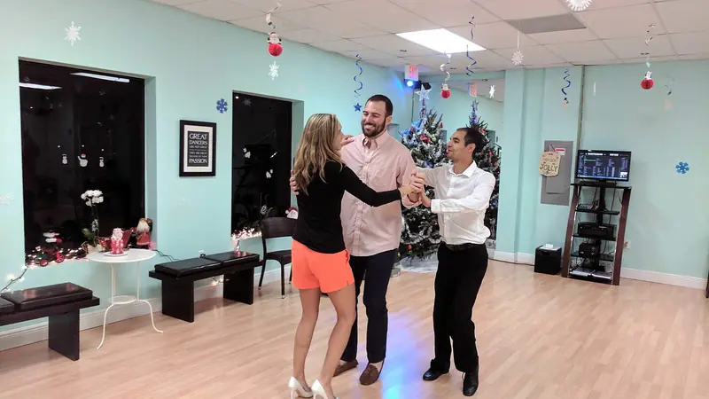 A couple practicing their wedding dance with an instructor