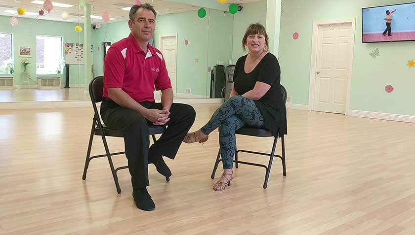 Ivan sitting with a student on the Dance Passion studio floor